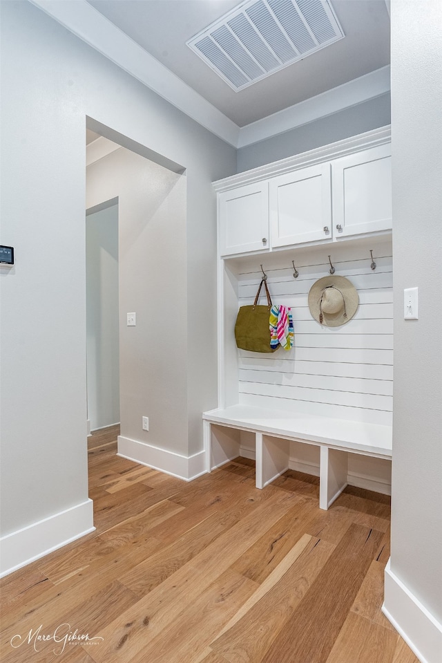 mudroom featuring visible vents, baseboards, and light wood-style floors