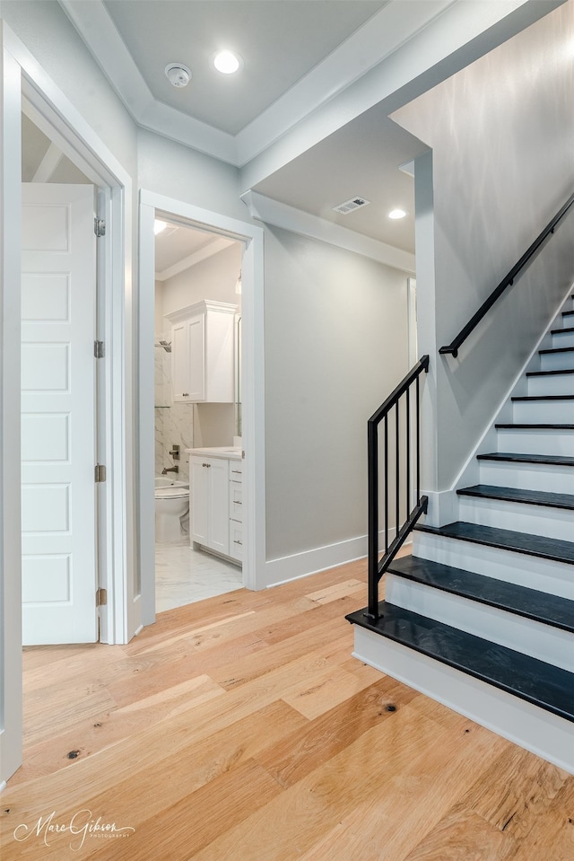 stairs with visible vents, wood finished floors, recessed lighting, crown molding, and baseboards