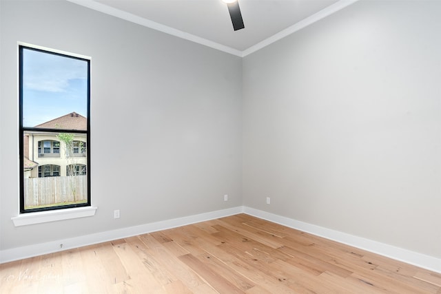 empty room featuring a ceiling fan, baseboards, light wood finished floors, and ornamental molding