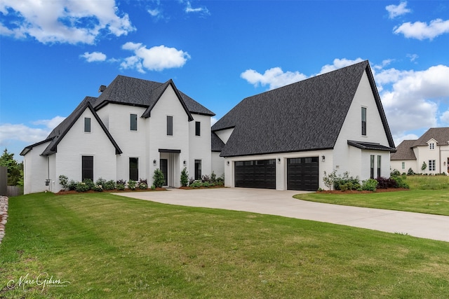 view of front of house featuring a front yard, driveway, and a shingled roof