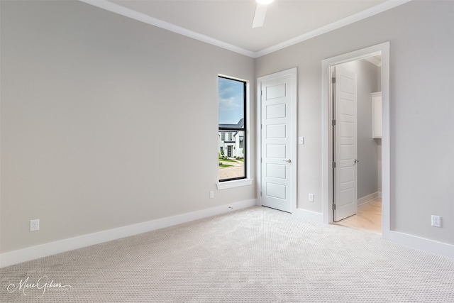 unfurnished bedroom with light colored carpet, a ceiling fan, baseboards, and ornamental molding