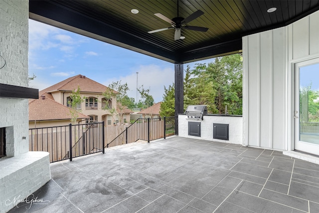 view of patio featuring exterior kitchen, area for grilling, and a ceiling fan