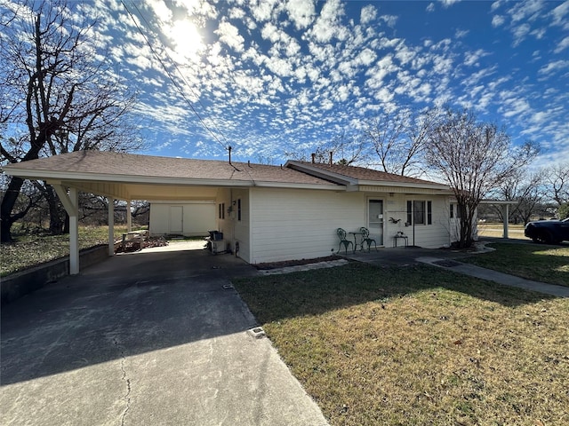 ranch-style home featuring a front lawn and a carport