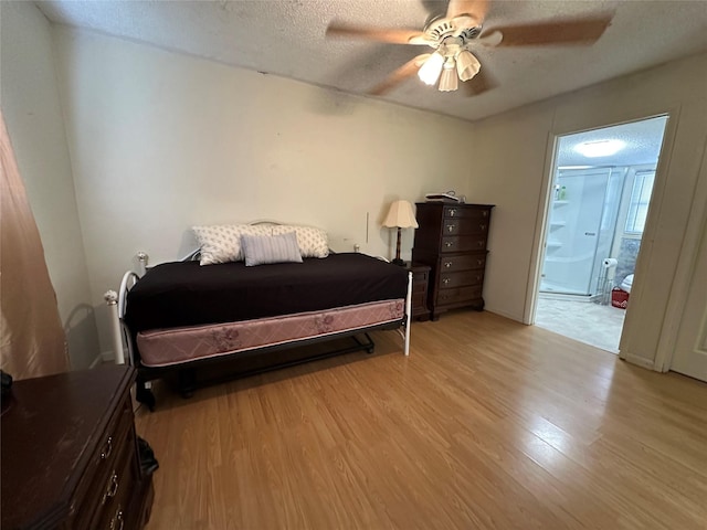 bedroom featuring ceiling fan, a textured ceiling, connected bathroom, and light hardwood / wood-style flooring