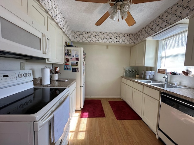 kitchen featuring a textured ceiling, white appliances, sink, and light hardwood / wood-style flooring