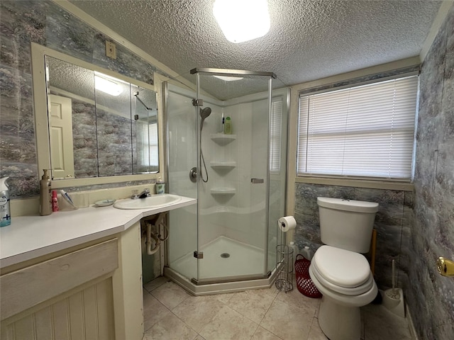 bathroom with tile patterned floors, walk in shower, vanity, a textured ceiling, and toilet