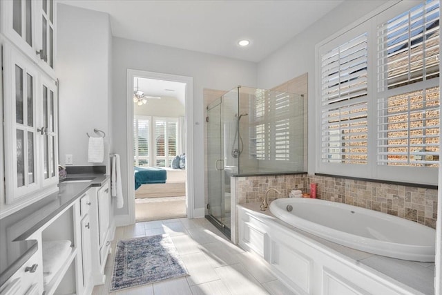 bathroom with tile patterned floors, vanity, ceiling fan, and plus walk in shower