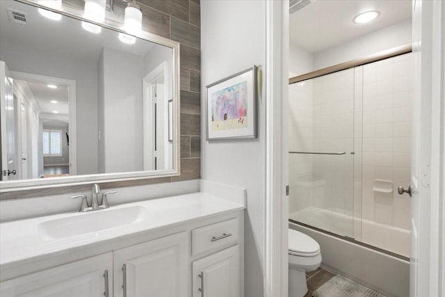 full bathroom with toilet, vanity, and combined bath / shower with glass door