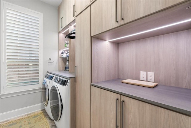 laundry room with washer and dryer and cabinets