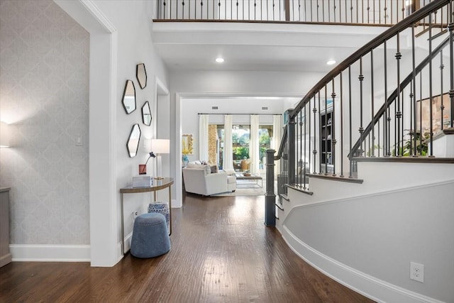 entrance foyer with a towering ceiling and wood-type flooring