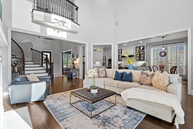 living room with a towering ceiling and dark hardwood / wood-style floors