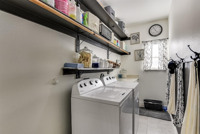 clothes washing area featuring washer and dryer and light tile patterned floors