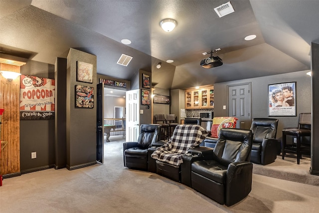 home theater featuring carpet floors and vaulted ceiling