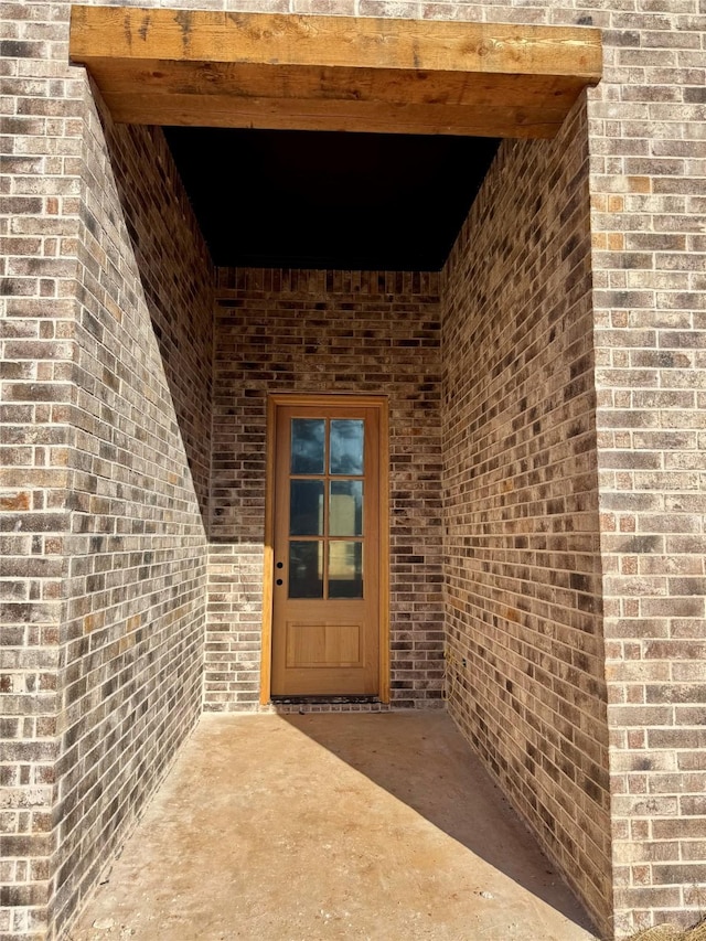 view of exterior entry with a patio