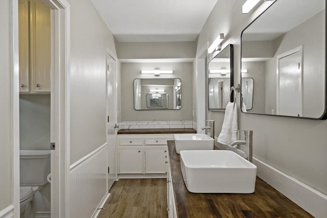 bathroom with wood-type flooring, vanity, and toilet