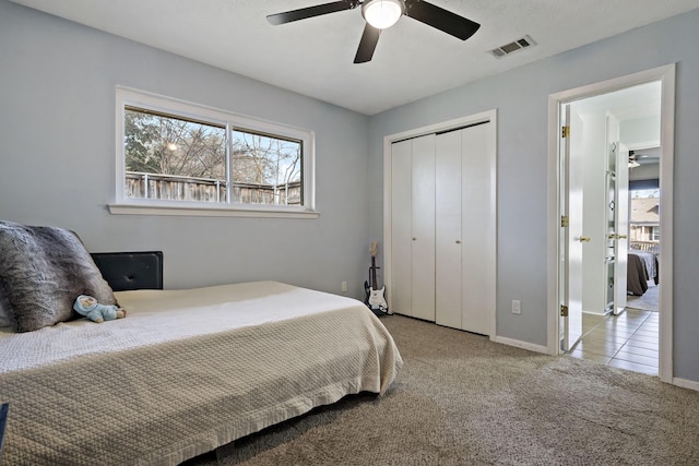 carpeted bedroom featuring ceiling fan and a closet