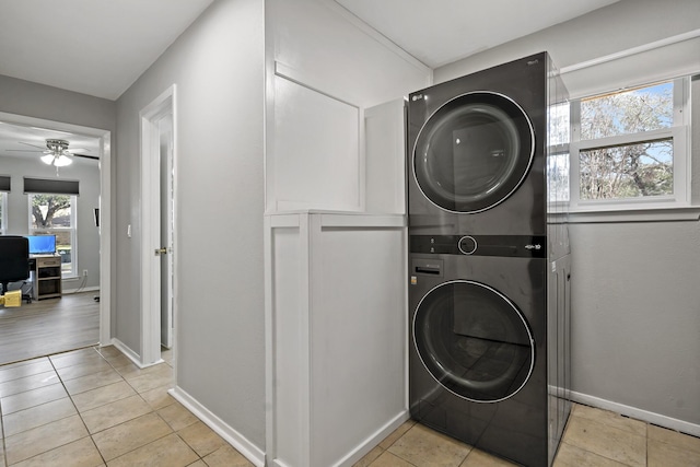 laundry area featuring light tile patterned floors, ceiling fan, and stacked washer / drying machine