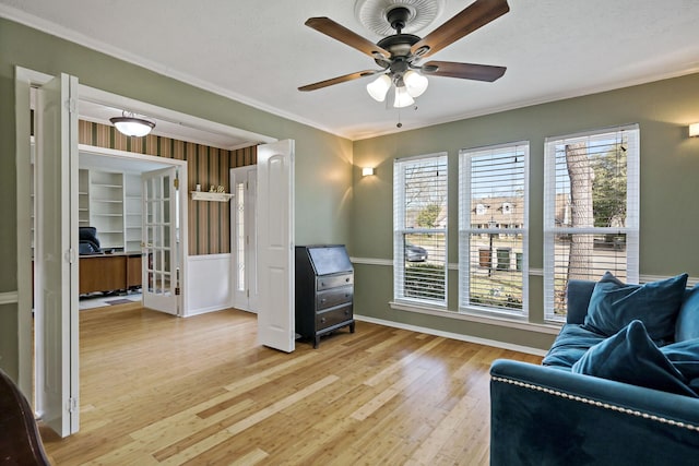 living area with ceiling fan, light hardwood / wood-style floors, and ornamental molding