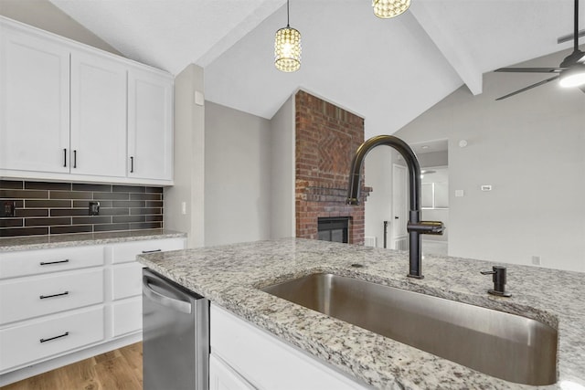 kitchen with dishwasher, sink, vaulted ceiling with beams, decorative backsplash, and white cabinets