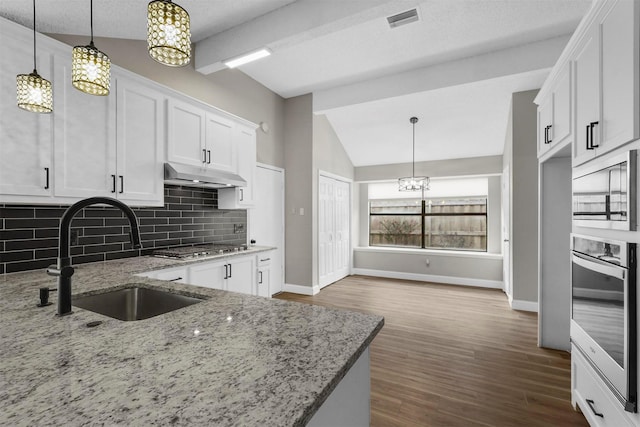 kitchen with white cabinetry, sink, stainless steel appliances, and decorative light fixtures