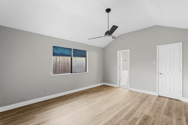 unfurnished bedroom with ensuite bath, a textured ceiling, ceiling fan, light hardwood / wood-style flooring, and lofted ceiling