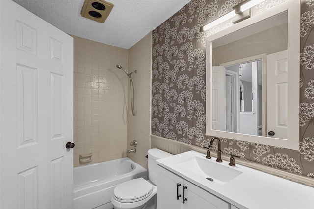 full bathroom with vanity, a textured ceiling, toilet, tiled shower / bath, and wood walls