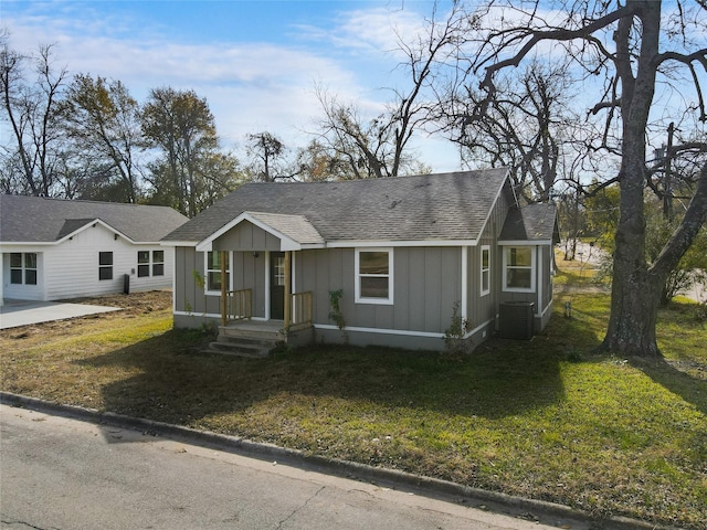 single story home featuring a front lawn and cooling unit