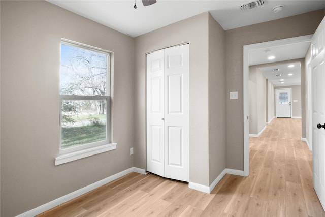 hall with plenty of natural light and light hardwood / wood-style floors