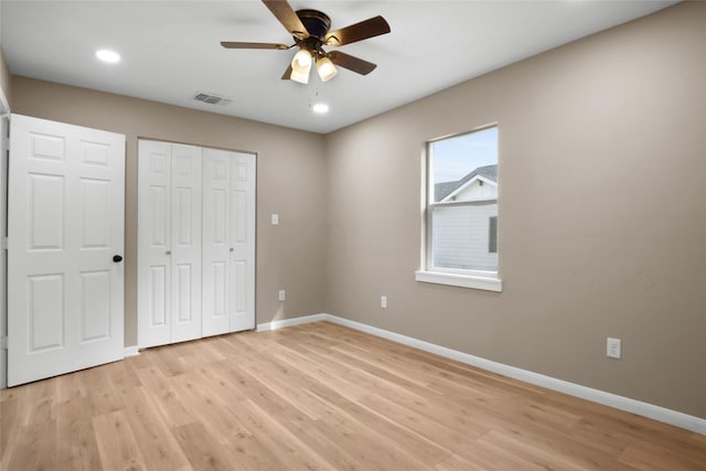 unfurnished bedroom with ceiling fan, a closet, and light hardwood / wood-style flooring