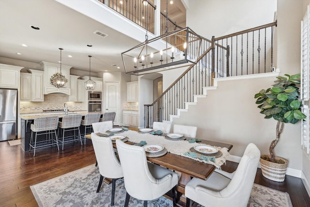 dining space with a high ceiling and dark hardwood / wood-style floors