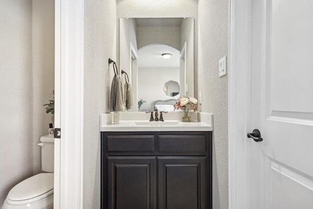 bathroom featuring vanity and toilet