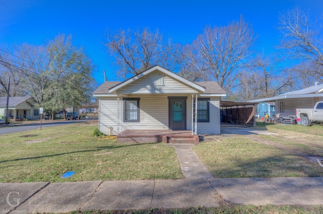 bungalow-style house featuring a porch, a carport, and a front lawn