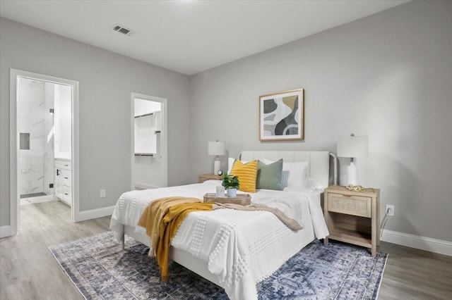 bedroom with hardwood / wood-style flooring and ensuite bath