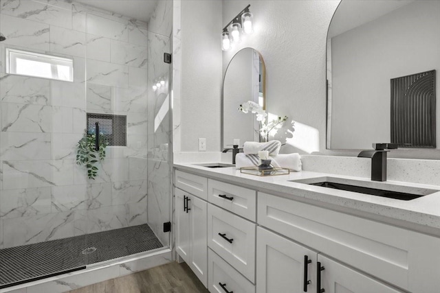 bathroom featuring hardwood / wood-style floors, vanity, and tiled shower