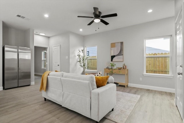 living room featuring ceiling fan, a healthy amount of sunlight, and light hardwood / wood-style flooring