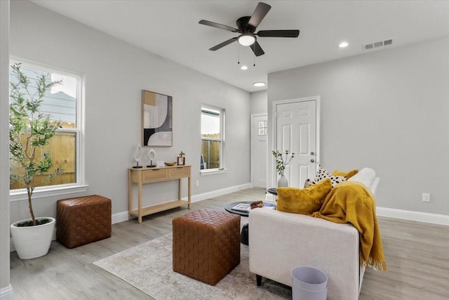 living room with ceiling fan and light wood-type flooring