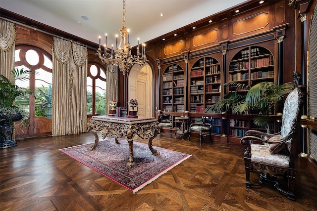 home office with dark parquet flooring, wood walls, and a notable chandelier