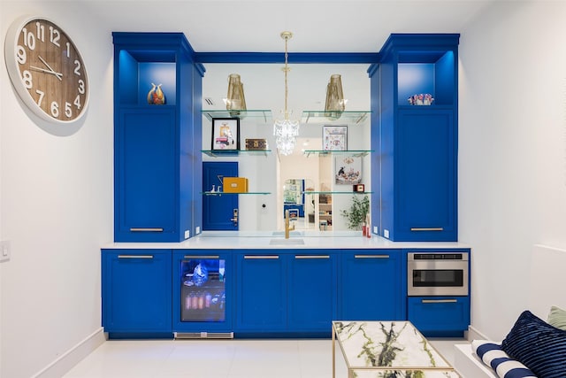 bar featuring oven, beverage cooler, decorative light fixtures, and blue cabinets