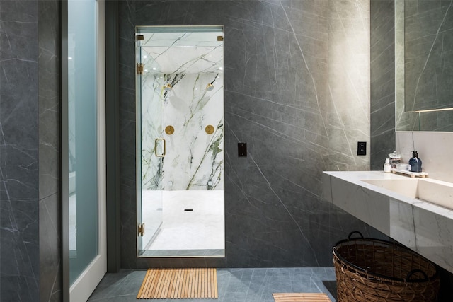 bathroom with an enclosed shower, tile patterned flooring, and tile walls