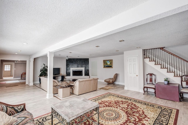 living room with hardwood / wood-style flooring, a fireplace, and a textured ceiling