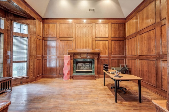 office space with a high end fireplace, light wood-type flooring, and lofted ceiling