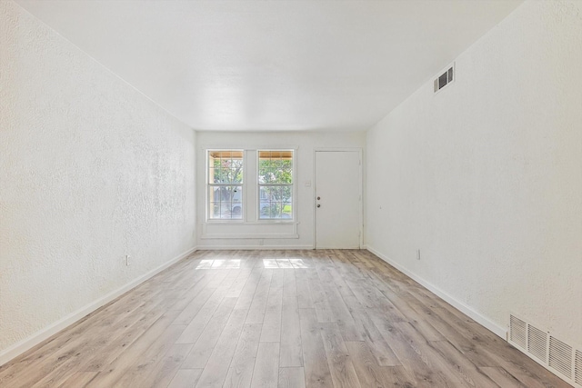 empty room with light hardwood / wood-style flooring