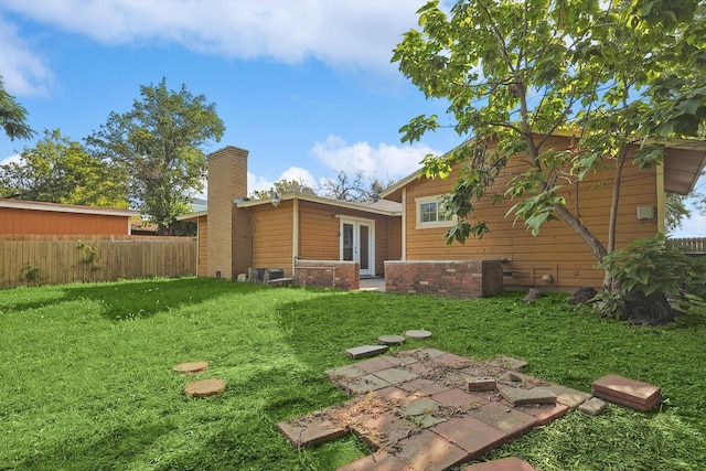 back of property featuring a yard and french doors