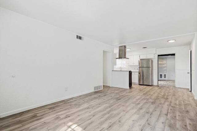 unfurnished living room featuring light hardwood / wood-style flooring and sink