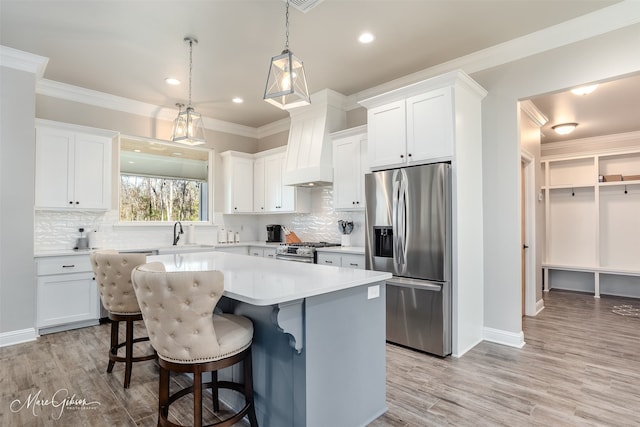 kitchen featuring white cabinetry, a center island, stainless steel appliances, and custom range hood