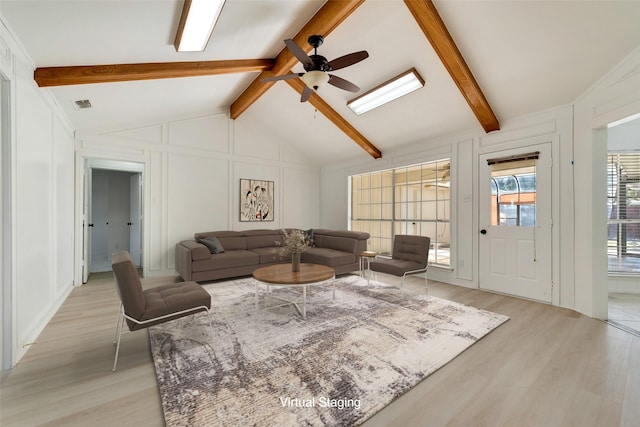 living room featuring ceiling fan, light wood-type flooring, and lofted ceiling with beams