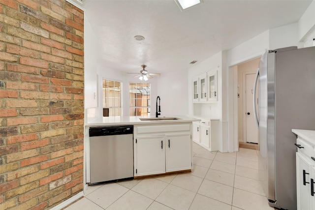 kitchen featuring stainless steel appliances, sink, white cabinetry, ceiling fan, and light tile patterned floors