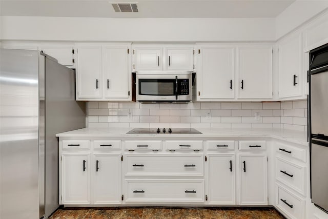 kitchen with light stone countertops, decorative backsplash, white cabinetry, and appliances with stainless steel finishes