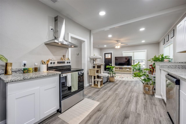 625 S Montgomery St, Sherman, TX 75090 - kitchen with appliances with stainless steel finishes, wall chimney range hood, white cabinetry, recessed lighting, and light wood-type flooring