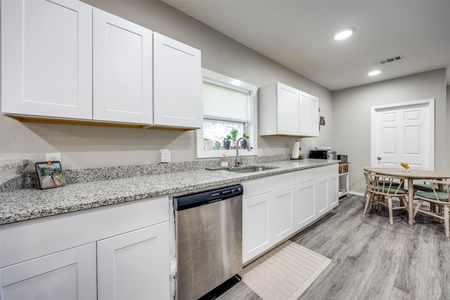 kitchen featuring dishwasher, light wood-type flooring, light stone countertops, sink, and white cabinetry